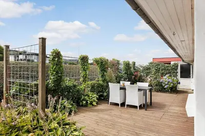 a patio with a table and chairs on a deck at G295-Lemvig-Syrenvej-95 in Lemvig