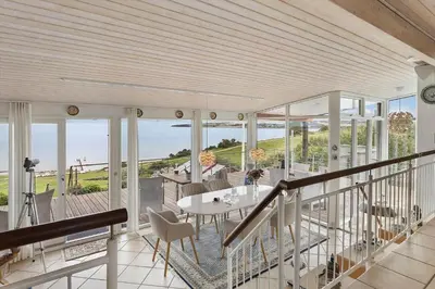 a house with a balcony with a table and chairs at G295-Lemvig-Syrenvej-95 in Lemvig