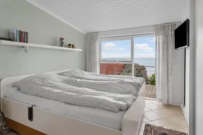 a white bedroom with a bed with a window at G295-Lemvig-Syrenvej-95 in Lemvig