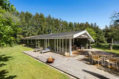 a house with a deck with a fire pit at LK1123-Lokken-Piasvej-16 in Løkken
