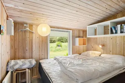 a bedroom with a bed and a window in it at LK1123-Lokken-Piasvej-16 in Løkken