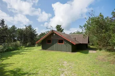 a green building with a red roof on a grass field at LK473-Lokken-Kettrup-Bjerge-Vej-47 in Løkken