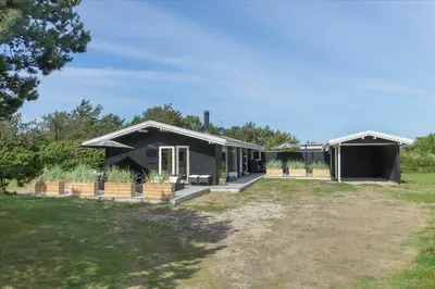 a house with a black roof and a yard at LK1706-Lokken-Redningsstien-20-A in Løkken