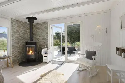a living room with a fireplace and a patio at LK1706-Lokken-Redningsstien-20-A in Løkken