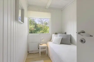 a white bedroom with a bed and a window at LK1706-Lokken-Redningsstien-20-A in Løkken