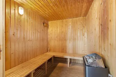 a wooden sauna with a bench and a trash can at LK1001-Lokken-Nellysvej-21 in Løkken