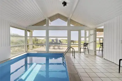 a swimming pool in a house with a large window at LK1001-Lokken-Nellysvej-21 in Løkken