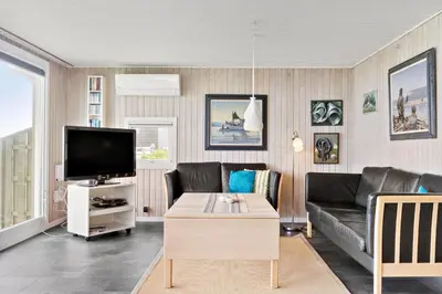 a living room with a couch and a tv at LK1456-Lokken-Magdavej-9 in Løkken