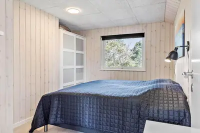 a bedroom with a bed in a room with a window at LK1924-Lokken-Lydiavej-4 in Løkken