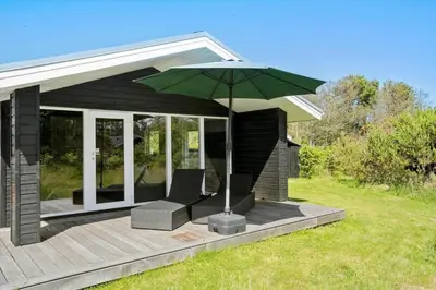 a patio with two chairs and an umbrella at LK1924-Lokken-Lydiavej-4 in Løkken