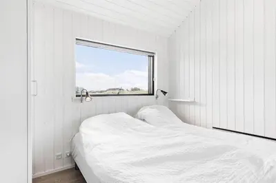 a white room with two beds and a window at LK1240-Lokken-Rosavej-13 in Løkken
