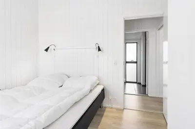 a white bedroom with a large bed and a hallway at LK1240-Lokken-Rosavej-13 in Løkken