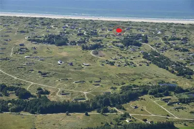 a red frisbee flying over a field next to the ocean at LK1240-Lokken-Rosavej-13 in Løkken