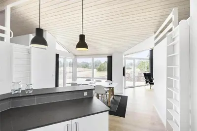 a kitchen with white cabinets and a dining room at LK1423-Lokken-Rikkesvej-4 in Løkken