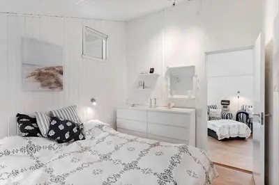 a white bedroom with a bed and a sink at LK2087-Lokken-Karinavej-54 in Løkken
