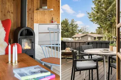 a porch with a wood stove and a table with chairs at LK2098-Lokken-Magdalenevej-51 in Løkken