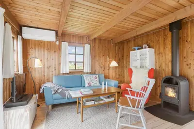 a living room with a blue couch and a stove at LK2098-Lokken-Magdalenevej-51 in Løkken