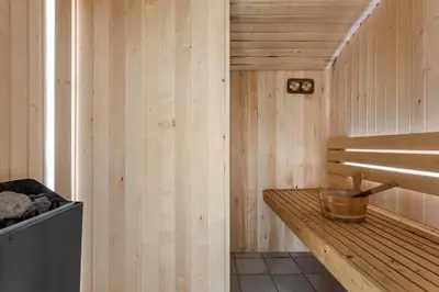 a wooden sauna with a wooden bench in a room at LK1892-Lokken-Marthinesvej-37 in Løkken