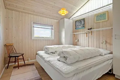 a bedroom with a bed with pillows on it at LK539-Lokken-Sylviavej-27 in Løkken