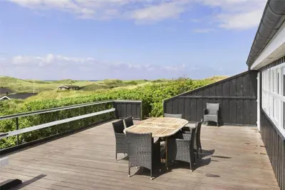 a wooden deck with a wooden table and chairs at LK552-Lokken-Ornegaardsvej-14 in Løkken