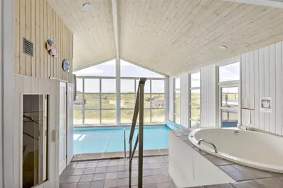 a large bathroom with a tub and a swimming pool at LK552-Lokken-Ornegaardsvej-14 in Løkken