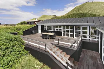 a building with a wooden deck with a table at LK552-Lokken-Ornegaardsvej-14 in Løkken