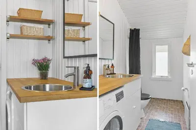 a bathroom with a sink and a washing machine at LK1999-Lokken-Magdalenevej-35 in Løkken