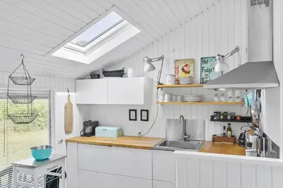 a kitchen with white cabinets and a sink at LK1999-Lokken-Magdalenevej-35 in Løkken