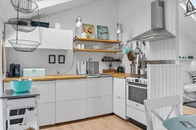 a kitchen with white cabinets and a stove top oven at LK1999-Lokken-Magdalenevej-35 in Løkken