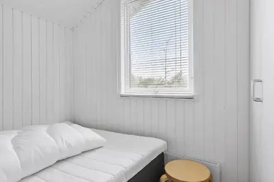 a white room with a bed and a window at LK1999-Lokken-Magdalenevej-35 in Løkken