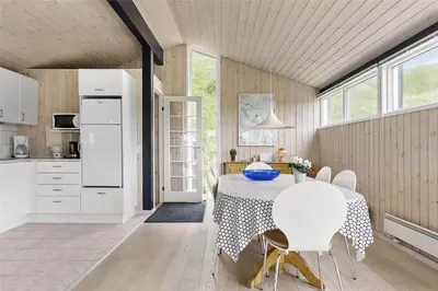 a kitchen and dining room with a table and chairs at LK157-Lokken-Ruthsvej-15 in Løkken