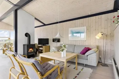 a living room with a couch and a table and a fireplace at LK157-Lokken-Ruthsvej-15 in Løkken