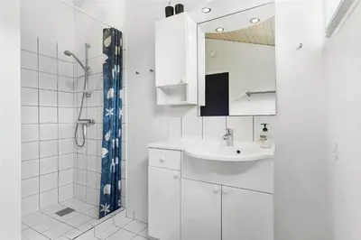 a white bathroom with a sink and a shower at LK157-Lokken-Ruthsvej-15 in Løkken