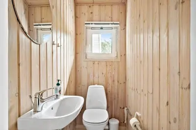 a bathroom with a sink and a toilet and a mirror at LK350-Lokken-Piasvej-11 in Løkken