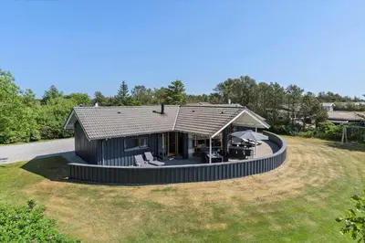 a small black house with a circular roof on a yard at LK1948-Lokken-Karinavej-48 in Løkken