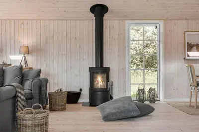 a living room with a wood stove in a room at LK1394-Lokken-Lisevej-5 in Løkken