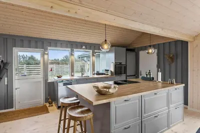 a kitchen with white cabinets and a wooden ceiling at LK1394-Lokken-Lisevej-5 in Løkken