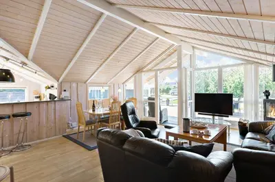 a living room with couches and a television and a table at LK1804-Lokken-Kristavej-43 in Løkken