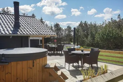 a patio with a grill and a table and chairs at LK1804-Lokken-Kristavej-43 in Løkken