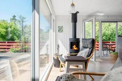 a living room with a fireplace on a patio at LK1935-Lokken-Pernillevej-17 in Løkken