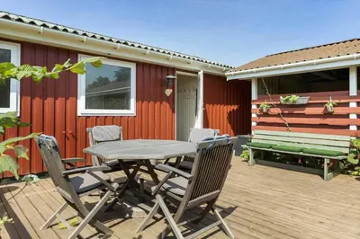 a patio with a table and chairs on a deck at LK1935-Lokken-Pernillevej-17 in Løkken