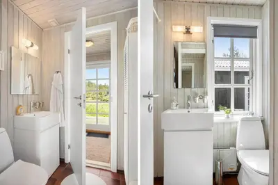 a bathroom with two sinks and a toilet and a mirror at LK344-Lokken-Ragnhildsvej-3 in Løkken