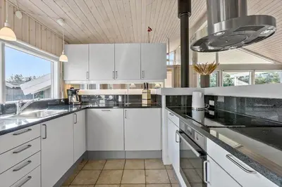 a kitchen with white cabinets and a large window at LK780-Lokken-Margrethevej-4 in Løkken