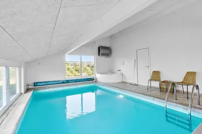 a swimming pool with blue water in a room at LK780-Lokken-Margrethevej-4 in Løkken