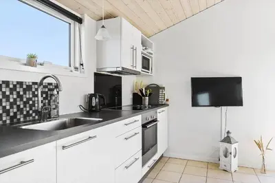 a kitchen with white cabinets and a sink at LK281-Lokken-Lonesvej-5 in Løkken