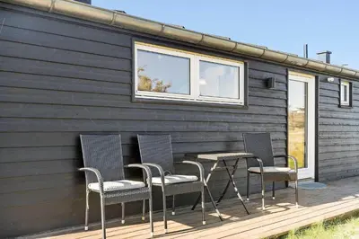 a group of chairs and a table on a deck at LK281-Lokken-Lonesvej-5 in Løkken