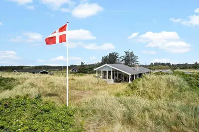 a flag in the middle of a field with a house at LK1786-Lokken-Nannasvej-18 in Løkken