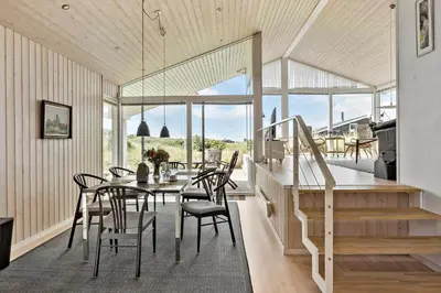 a dining room with a table and chairs and a staircase at LK1786-Lokken-Nannasvej-18 in Løkken