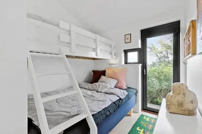 a bedroom with a bunk bed with a ladder at LK1946-Lokken-Kringelbaekvej-5 in Løkken