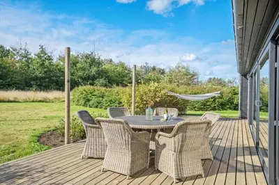 a patio with a table and chairs on a deck at LK1946-Lokken-Kringelbaekvej-5 in Løkken